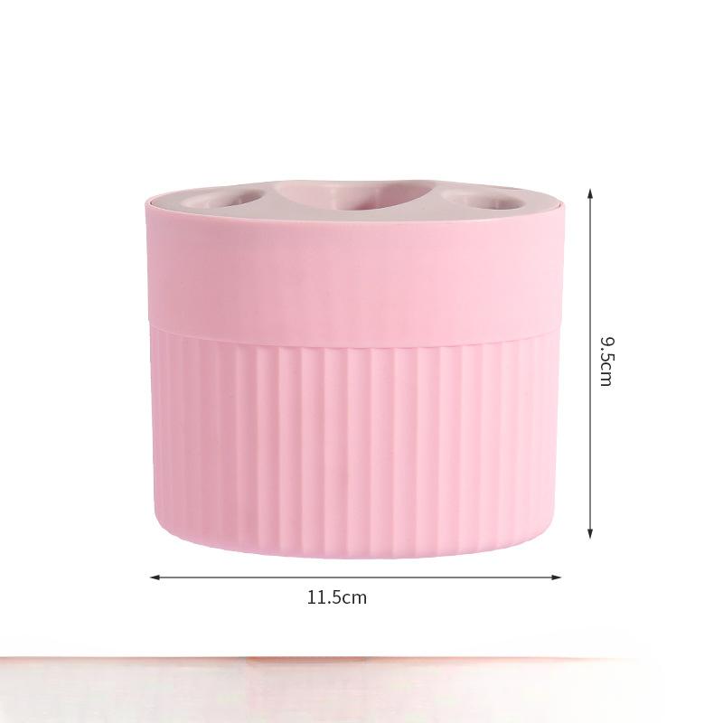 

Настільна підставка для зубних щіток, побутова підставка для умивальника, підставка для зберігання зубної пасти та зубних щіток і полиця для зберігання розміщені у ванній кімнаті. рожевий