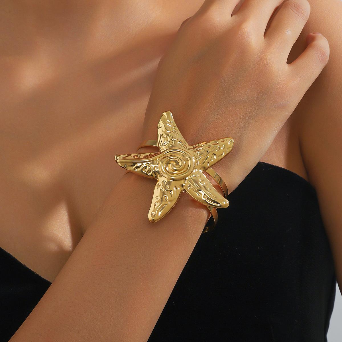 

Открытый браслет в виде преувеличенной морской звезды золотой