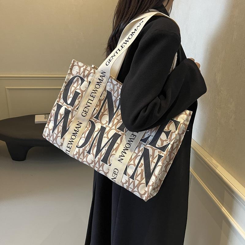 Large capacity alphabet canvas bag women's 2025 new fashion niche shoulder bag college student class commuter bag