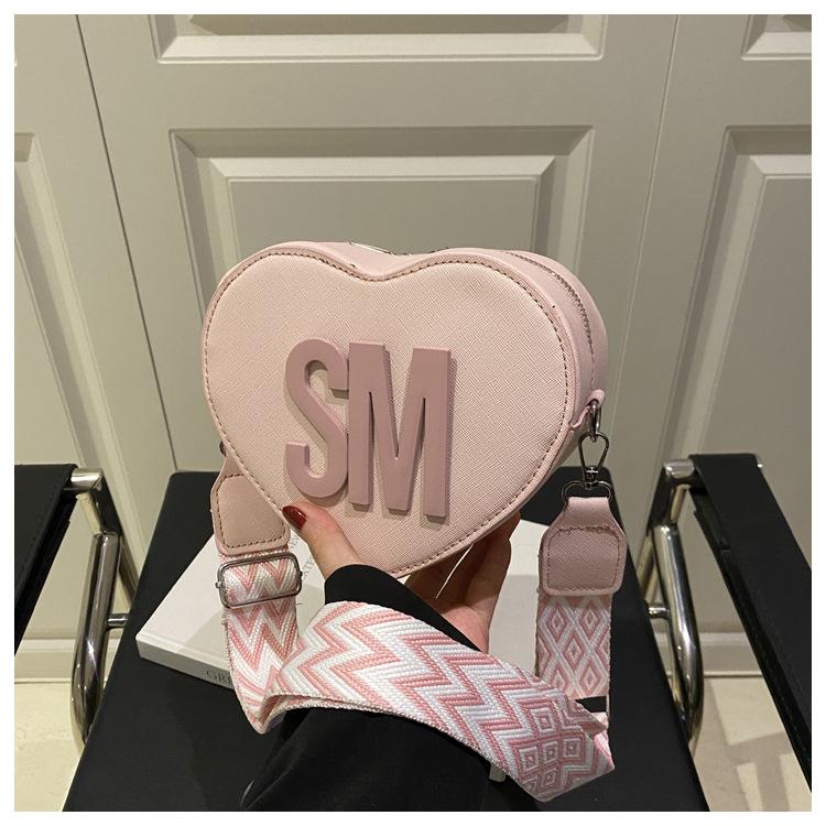 

Trend fashion women s bag heart-shaped personality niche versatile temperament high-grade texture shoulder messenger bag wide shoulder strap women s розовый