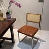 Elegantly crafted armless rattan dining chair in retro pastoral style, perfect for cafes, guesthouses, and vintage settings.