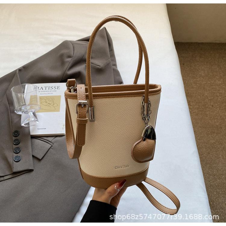 

New niche simple solid color lychee pattern texture hand carrying bucket bag versatile foreign style commuting messenger women s bag