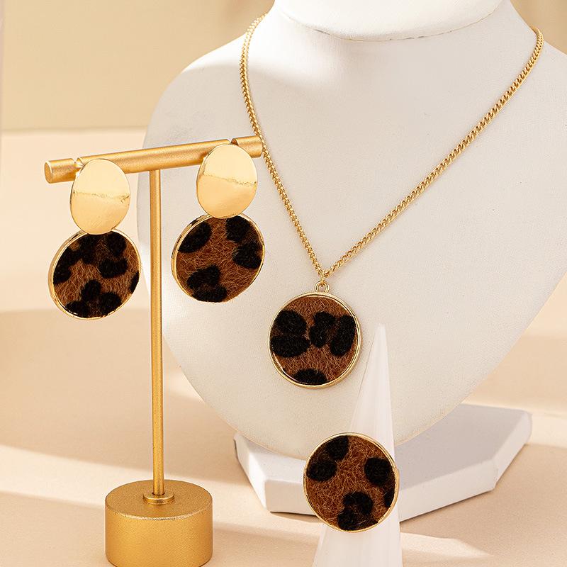 

Комплект из ожерелья, сережек и кольца с геометрическим рисунком в виде круга золотой