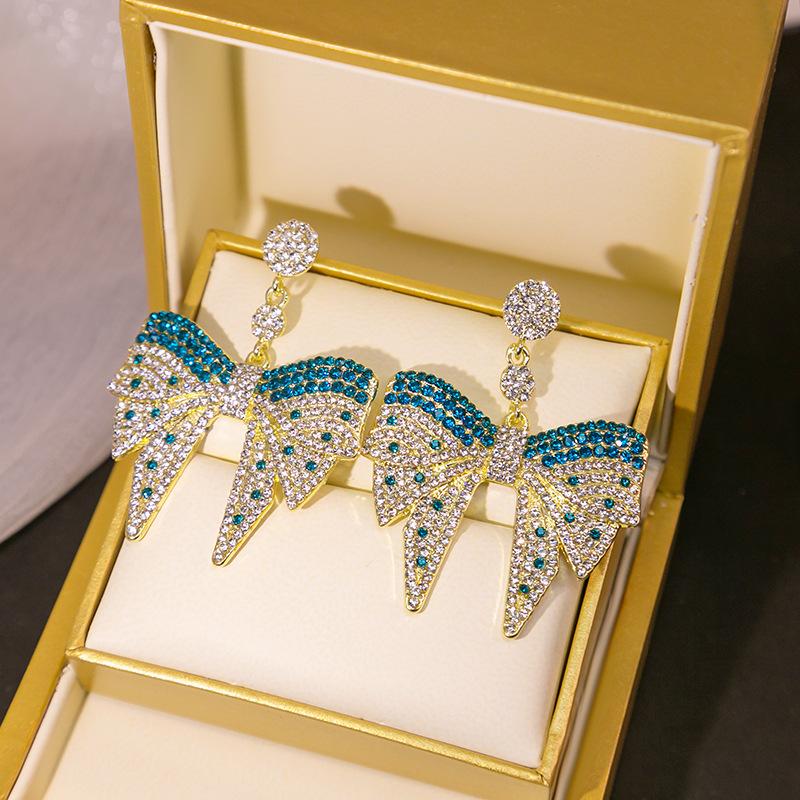 

Увеличенные и привлекательные серьги-капли в форме банта с мерцающими стразами синий