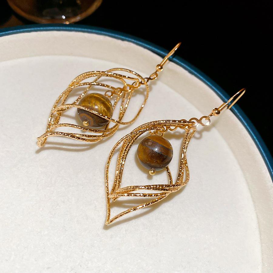 

Twisted rhombus tiger s eye stone pendant, ear hook, retro Maillard design sense, niche earrings, light luxury earrings.