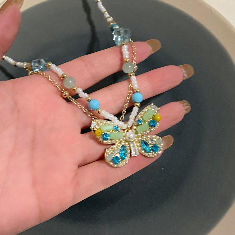 Pärlinlagd diamantfjäril pärlförsedd hänghalsband lätt lyx temperament hög känsla nyckelbenskedja nischmode mångsidiga smycken