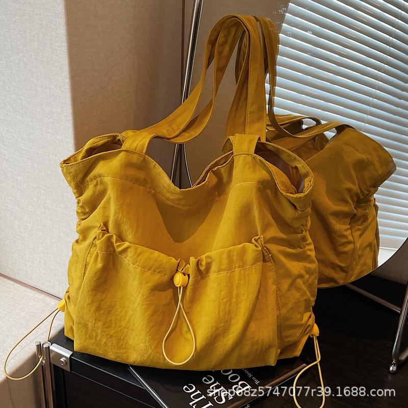 2025 new large-capacity drawstring canvas bag casual Korean version women's solid color daily commuting shoulder tote bag women