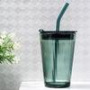 Gestreifter Glasbecher mit Deckel und Strohhalm
