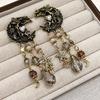 Pendientes de botón Vintage de Luna Dorada con Ángel y Borla de Cristal con Detalles de Esmalte
