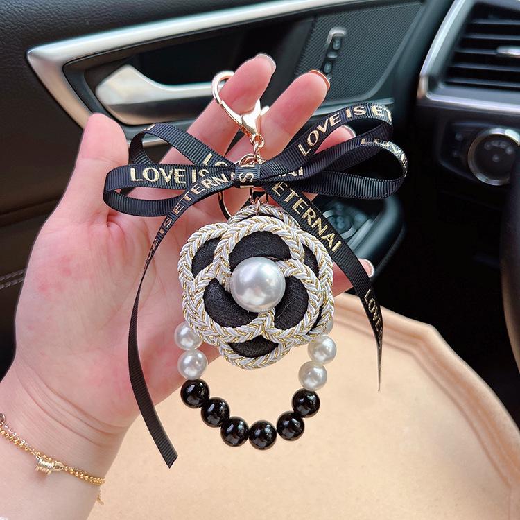 

Элегантный брелок с черным и белым жемчугом «Камелия» и бантом — стильный корейский цветочный брелок на сумку чёрный