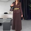 Damesett med mørkebrun blazer med gullknapper og bredt belte, matchende plisséskjørt, elegant kontorantrekk