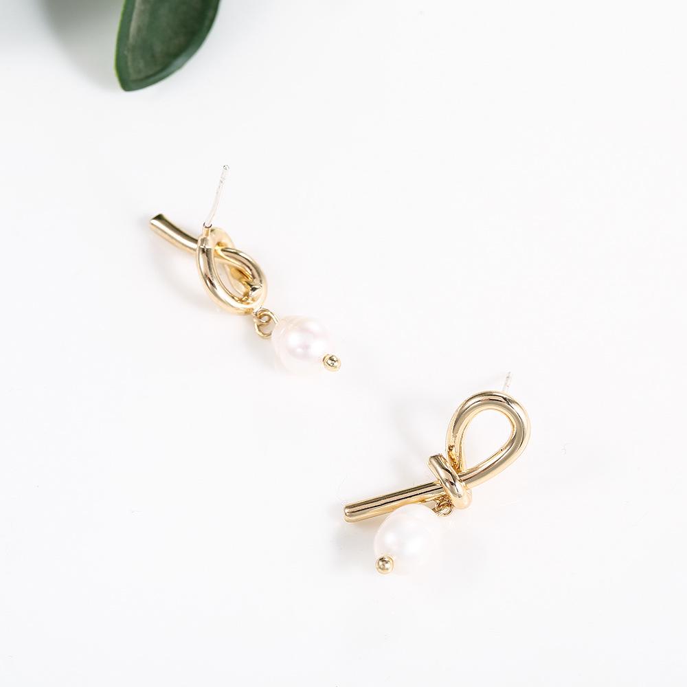 

Асимметричные серьги-пусеты из серебра 925 пробы с узлами и барочным жемчугом - Минималистичный стиль, трендовые подвески