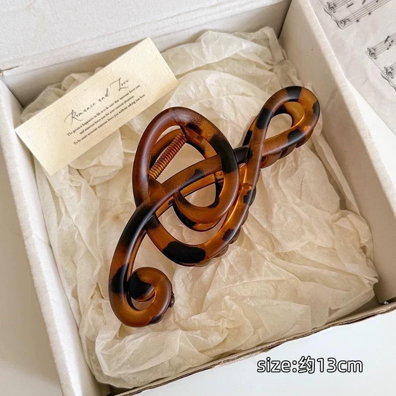 

Elegant Musical Note Shaped Hair Claw Features Fluid Sculptural Lines For Sophisticated Updos And Secure Daily Hold Matte Tortoise Note Claw