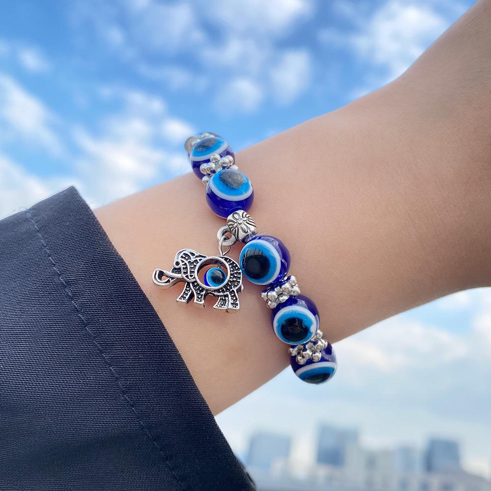 Beliebtes blaues Nazar-Armband mit Schmetterling-, Elefanten-, Fatimas Hand-Anhängern & Harzperlen
