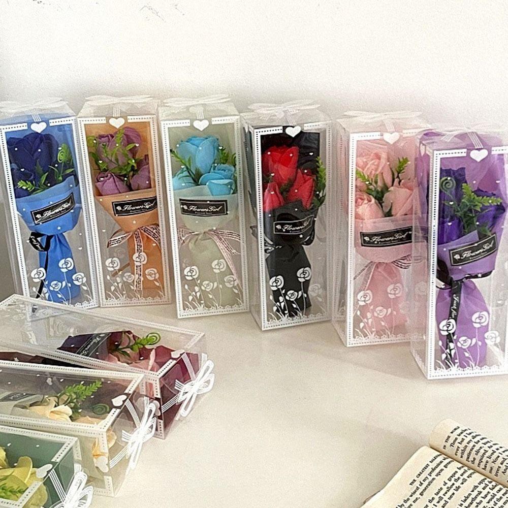 Rokā tur 3 mākslīgo rožu galvas ar kastīti mākslīgo ziedu modes rožu pušķis