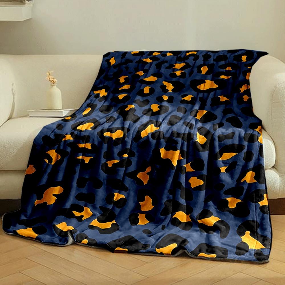 A leopard print pattern with orange and black spots on a navy background. for all seasons blanket lunch break throw gift
