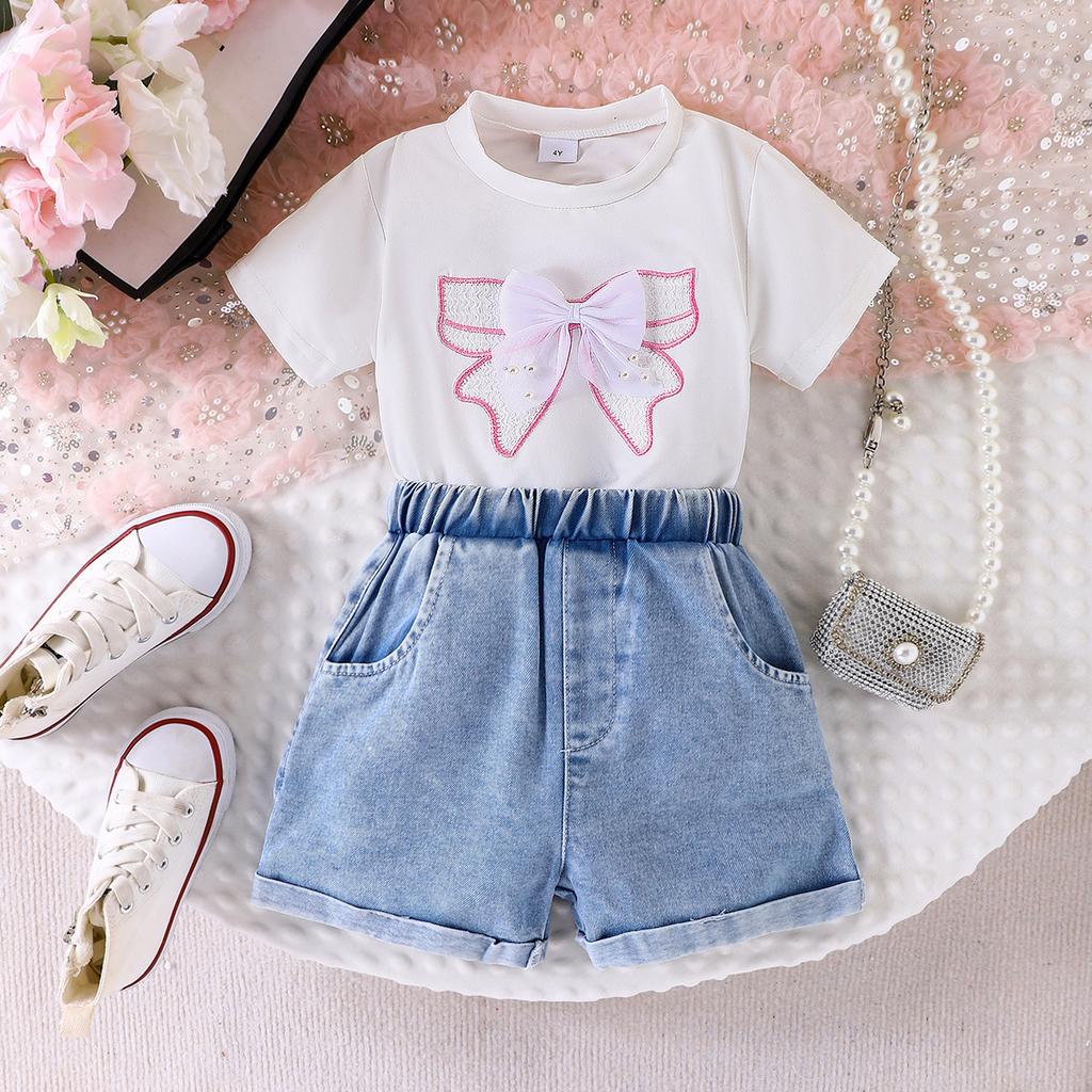 Zestaw modowy dla dziewcząt: Letni dziecięcy T-shirt w kolorze złamanej bieli z kokardą i dżinsowe szorty