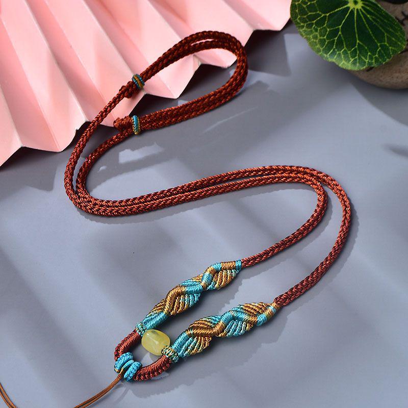 

Колье ручной работы из восьми плетеных шнуров золотого и серебряного цветов с подвеской из натурального янтаря Standard кирпич красный