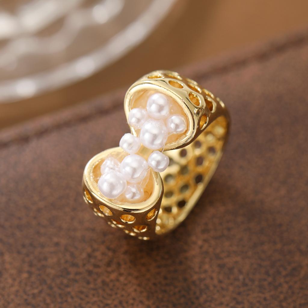 Creative and unique hollowed-out artificial imitation pearl ring made of copper. Suitable for women as a fashionable party gift.