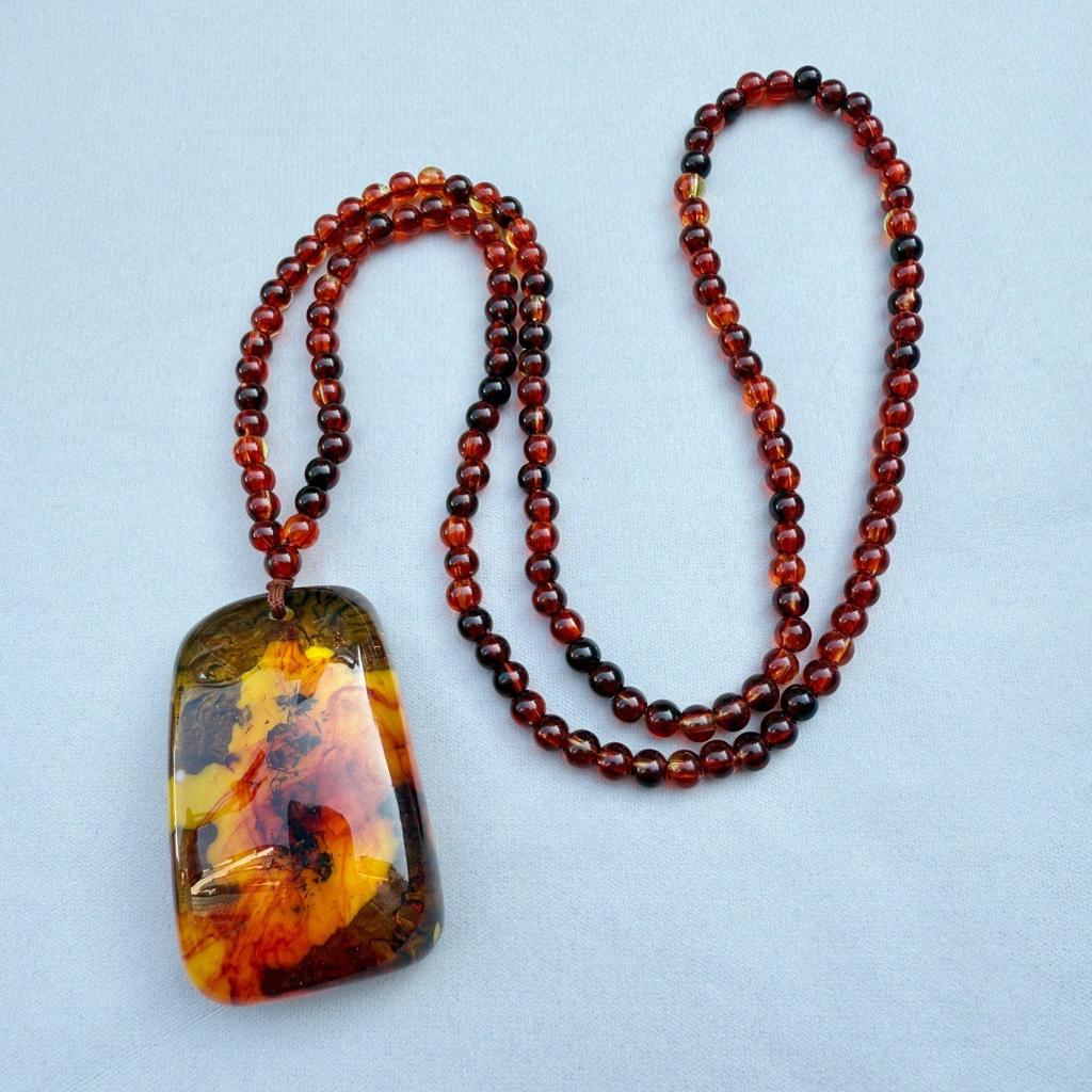  Bursztynowy Vintage Bursztynowy Wisiorek Naszyjnik Wiszący Dla Mężczyzn I Kobiet Z Krwistoczerwonymi Perłami. Naszyjnik Spokojny Urok na Łańcuszku w Etnicznym Swetrze.