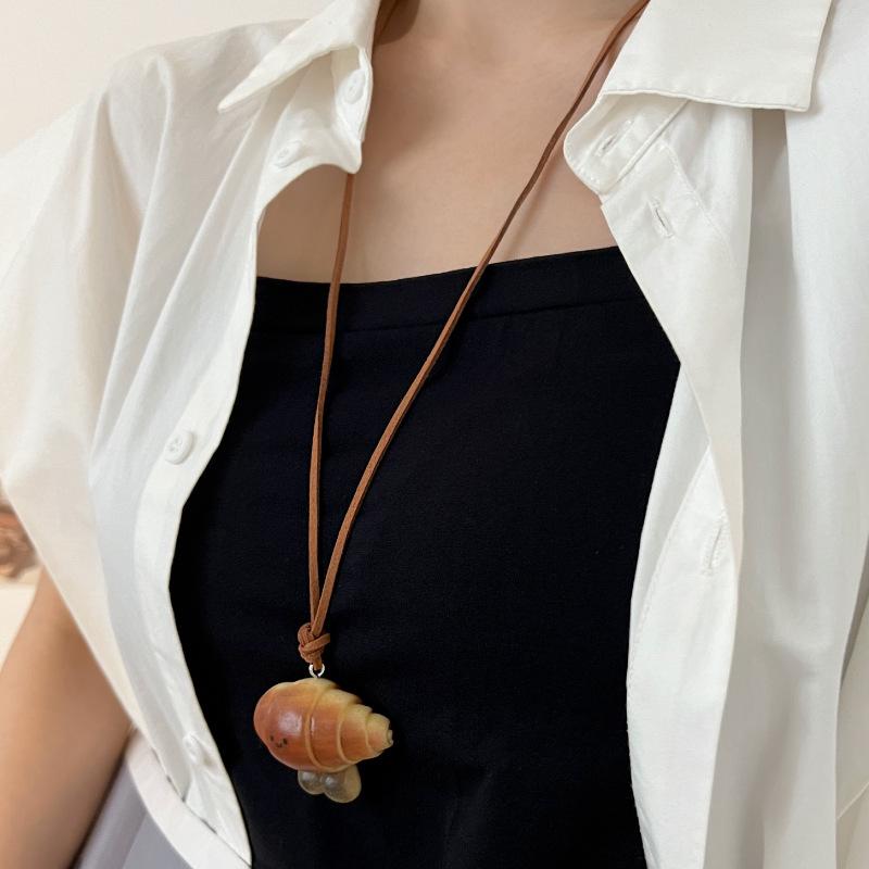 Women's Cute Knot Bread Pendant Necklace: Stylish Long Sweater Chain with Niche Design for a Fashionable Touch.