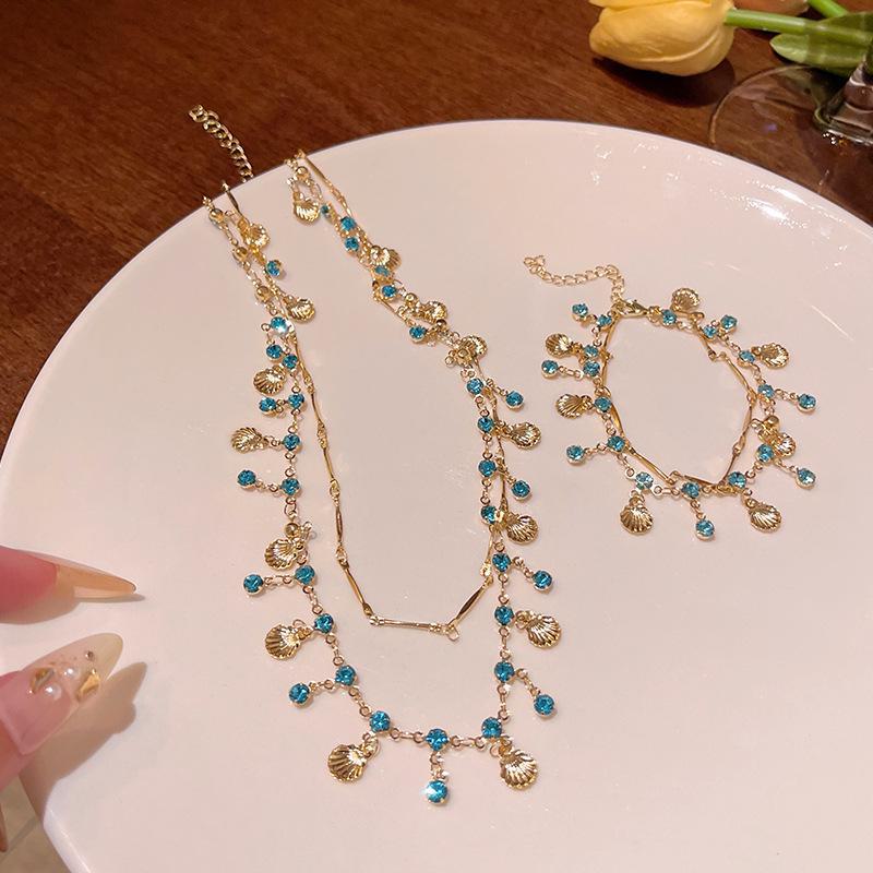 

Ожерелье из золотых ракушек «Дочь моря» с синим цирконием: Элегантные, универсальные, высококачественные украшения для женщин. bracelet золотой