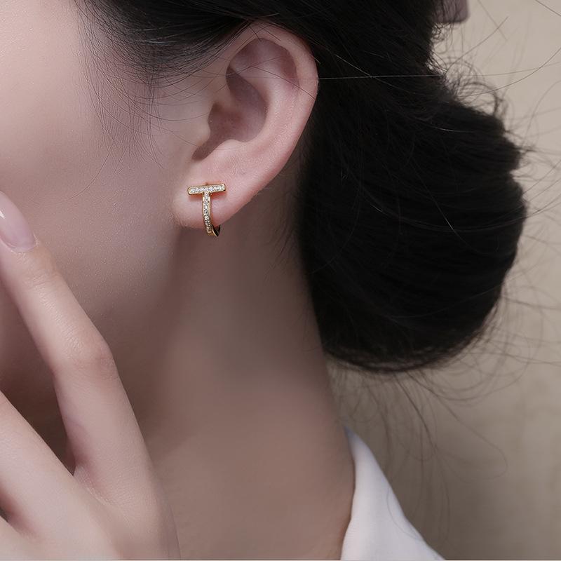 Modne kolczyki sztyfty z podwójnym T i pełnym diamentem, złote, luksusowe, z literą wykonaną techniką czystego igłowania