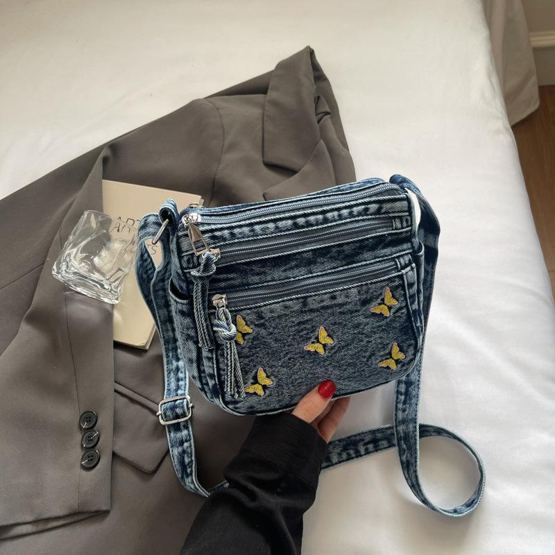 

Embroidered denim messenger bag multi-compartment summer change mobile phone bag fashionable and simple 2025 summer new small square bag темно-синього кольору