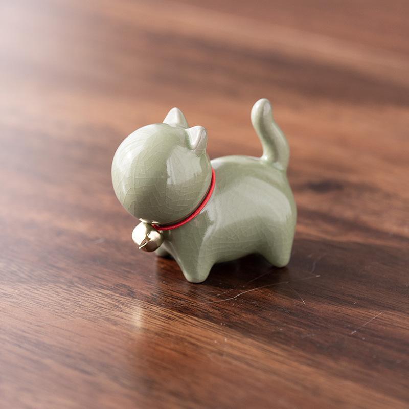 Eine kleine niedliche Katze im chinesischen Stil als Teehaustierfigur mit einem Keramik-Katzenpinselständer
