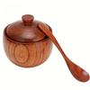 Eine native hölzerne Gewürzbox mit einem Löffel und Deckel, geeignet zum Kochen und Backen zu Hause. Es ist einfach zu bedienen und ein Muss in der Küche