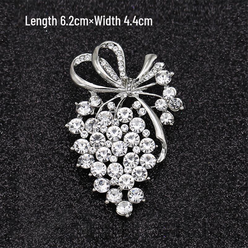 Módní brož s lukem: Kovové šperky s perlou a kamínkovou květinou