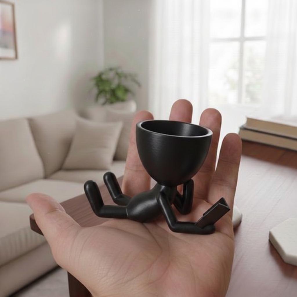 Black decorative pot for plants, lying reader, stylish