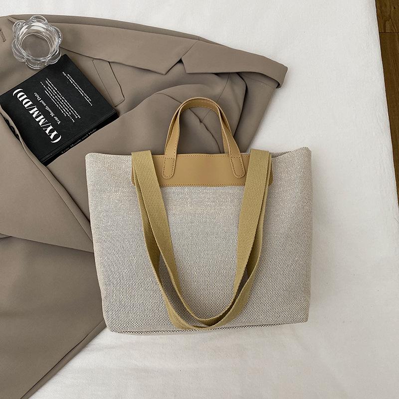 Fritid och konst splicing canvas 2025 vävning enkel ny temperament pendling mode tote bärbar axelväska