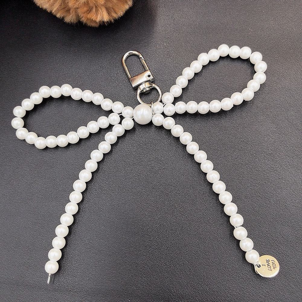 Fashionable Korean-inspired blogger-style large pearl bow mobile phone pendant key chain with heart design.
