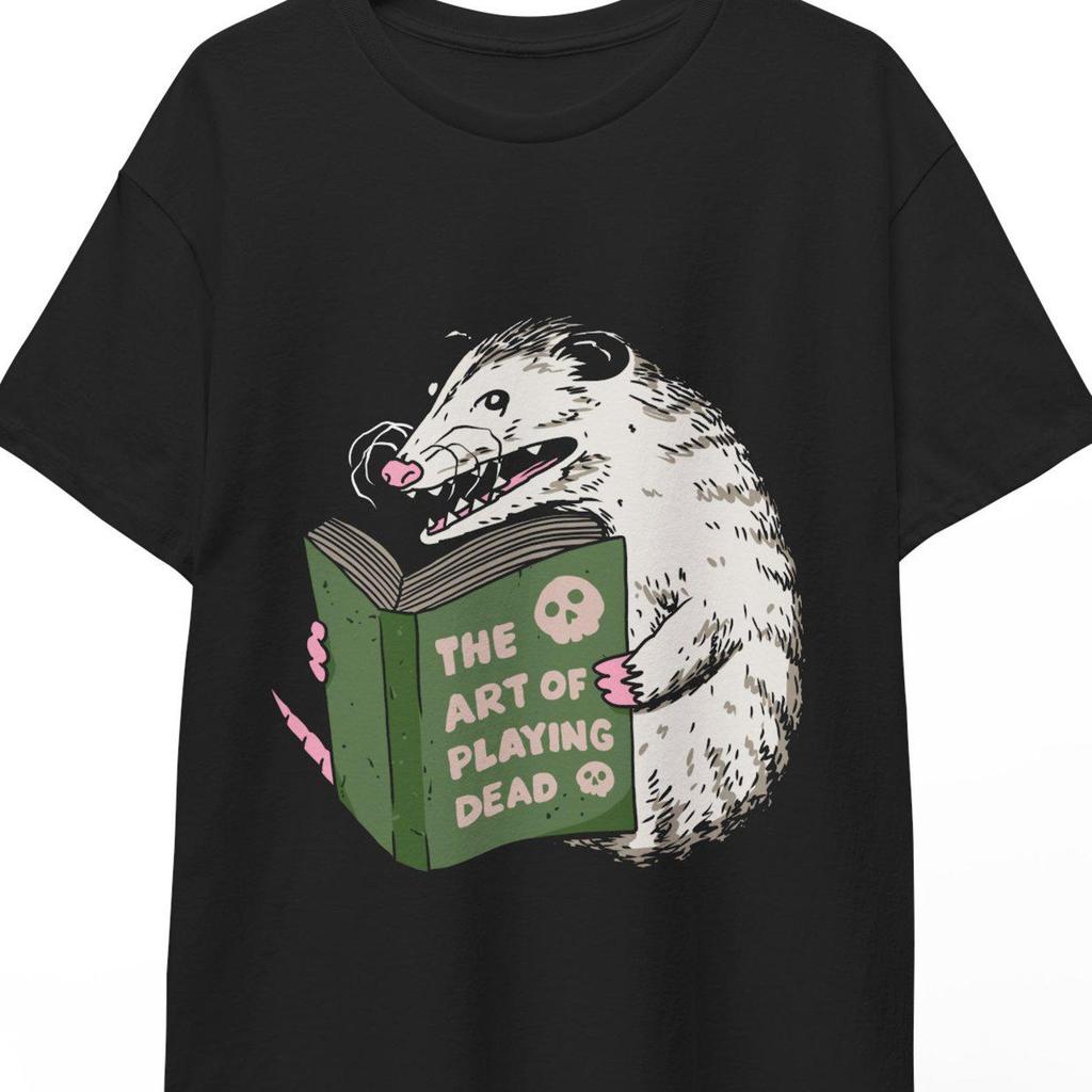 An opossum reading a book The art of playing dead Unisex T-shirt