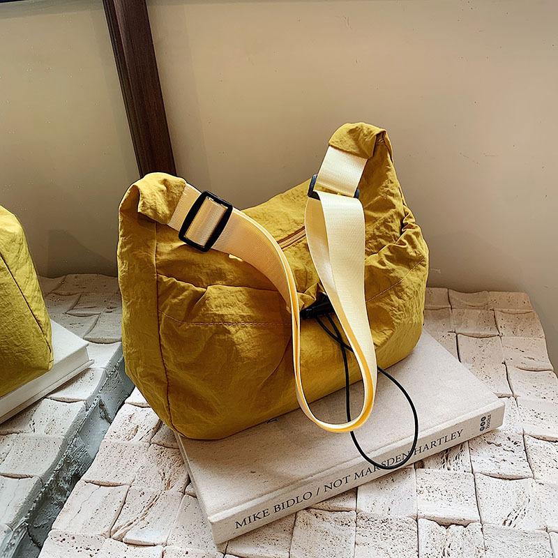 

Japanese literary and artistic nylon cloth drawstring simple 2025 leisure trend solid color shopping light shoulder messenger women s bag жовтий
