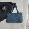 En denimväska med stor kapacitet En avslappnad och mångsidig toteväska för skola, pendling och en axelväska