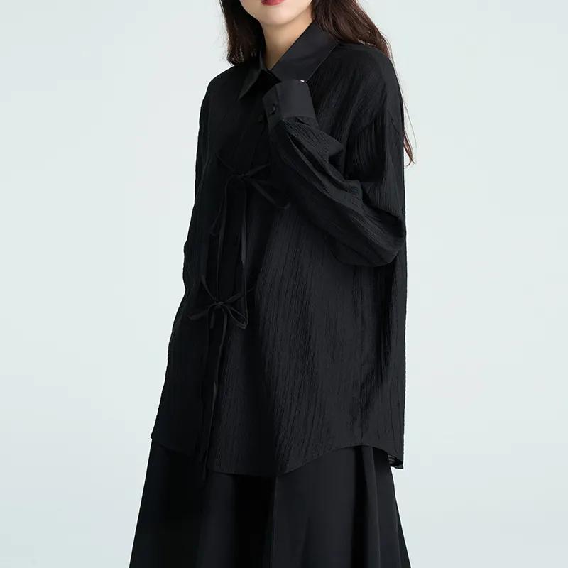 Camicia da donna nera testurizzata, casual, ampia, a maniche lunghe, con nodo sul davanti e bottoni.
