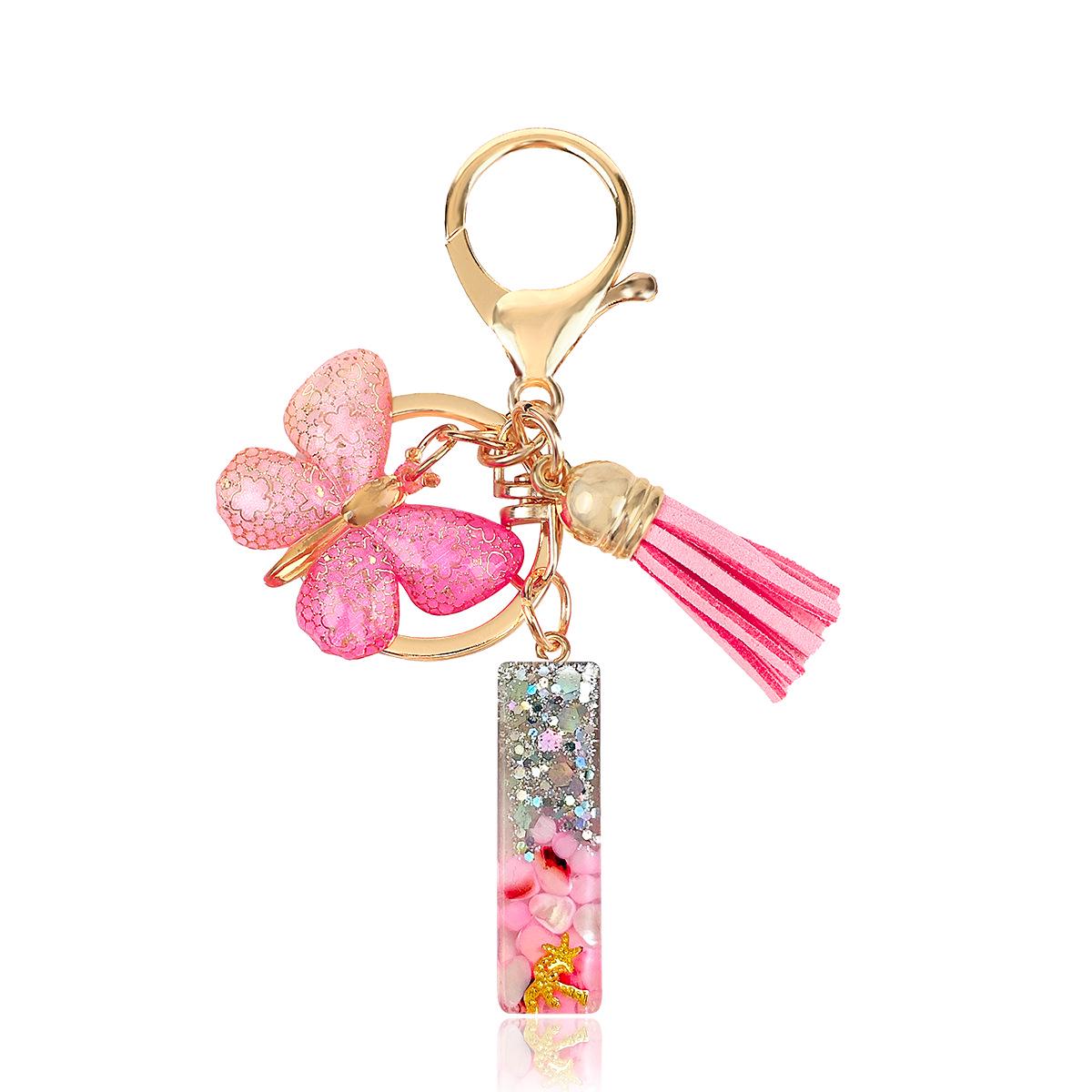 

Розовый брелок с эпоксидной буквой, пайеткой-бабочкой и кисточкой
