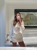 European & American Women's Fashion Tie-Up Cutout Patchwork Two-Piece Set: Round Neck Long Sleeve Top & Mini Skirt for Vacation or Casual Wear.