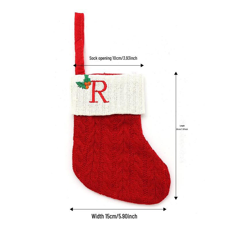 Weihnachtsdekorationen: Rote gestrickte Kinderstrümpfe mit gestickten Buchstaben