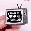 "You Are Not Immune To Propaganda" TV Meme Badges Promoting Enamel Pins