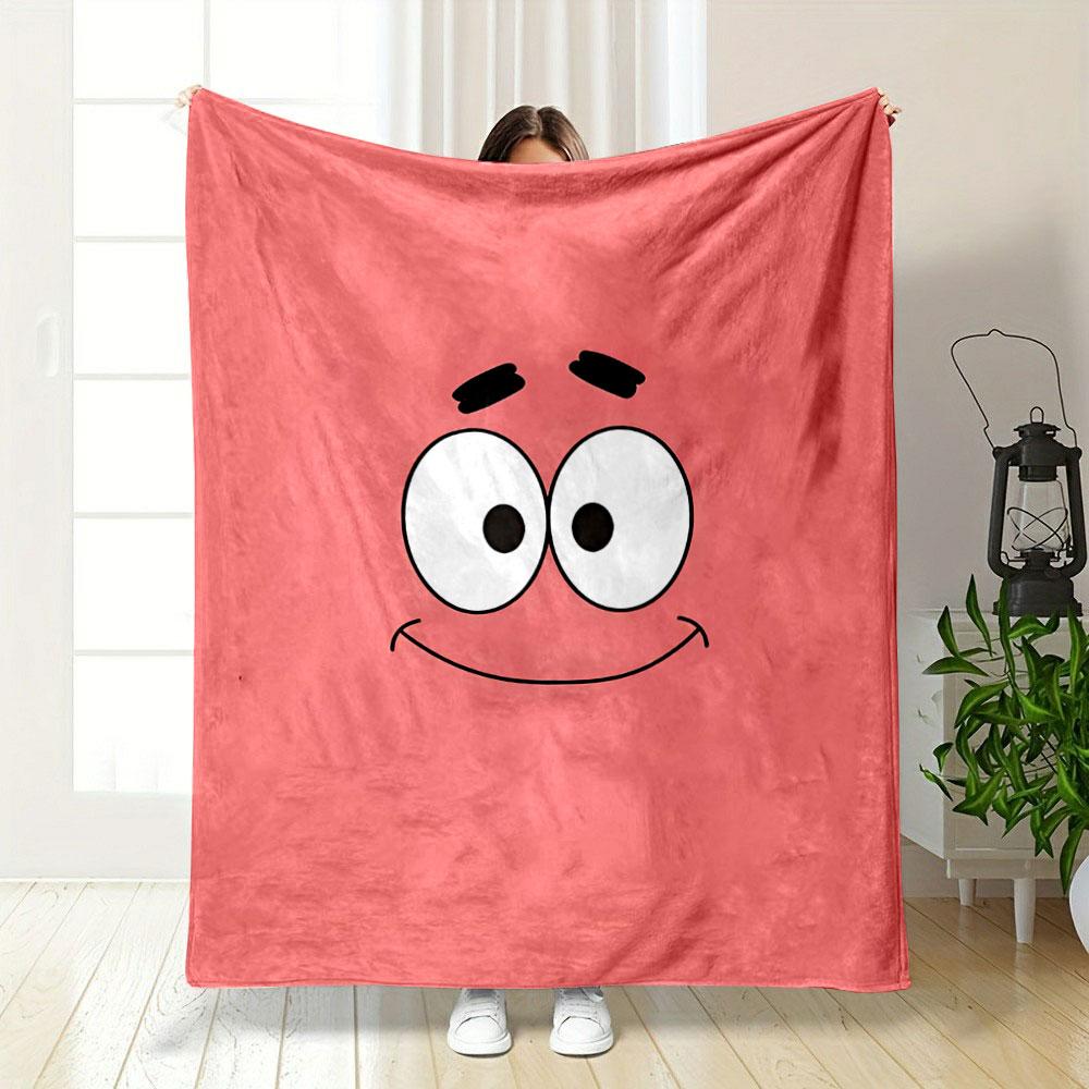 A simple pink background with a smiling cartoon face and wide eyes. for all seasons blanket lunch break throw gift
