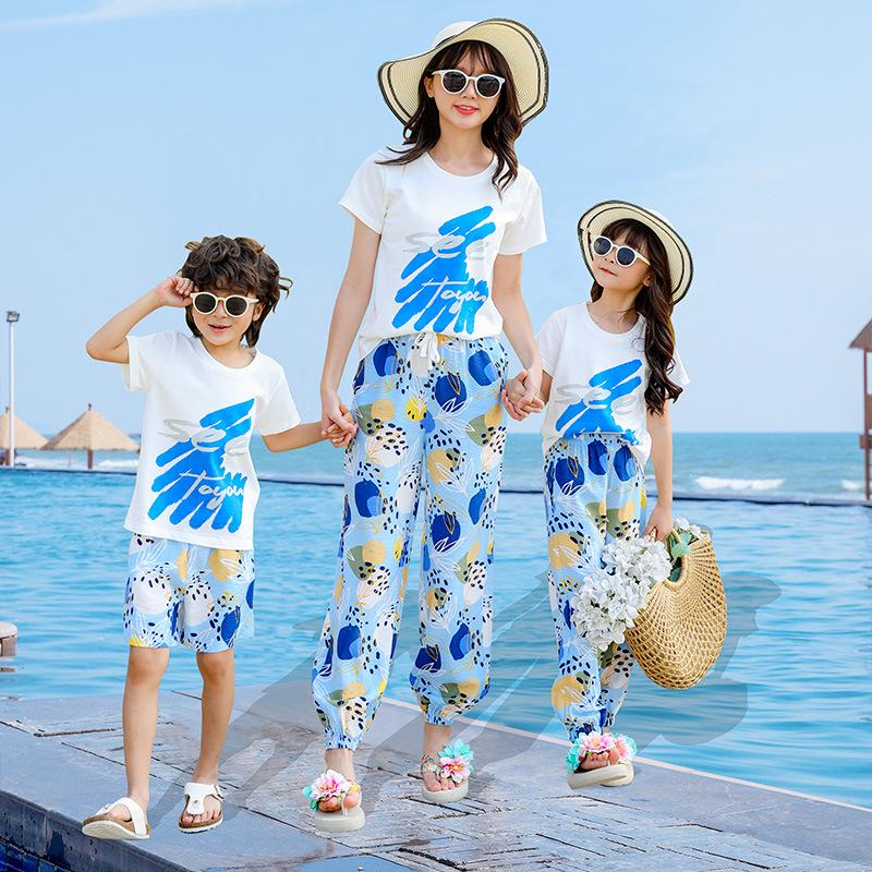 2025 Sommer-Strand-Eltern-Kind-Outfits: Fußanzüge der dreiköpfigen Familie am Meer