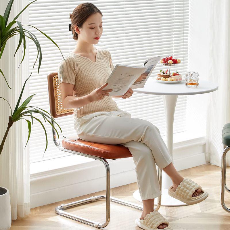 Elegantly crafted armless rattan dining chair in retro pastoral style, perfect for cafes, guesthouses, and vintage settings.