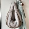 Плюшевая сумка через плечо с текстурой искусственного меха, на эластичном плечевом ремне и карманом для крупных предметов, напоминающая сумку-пельмень.