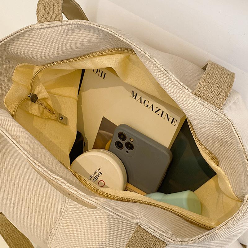 Koreanische Version tragbare Damen-Tasche für Pendler Winter Neu Ausländischer Stil Pendler-Achseltasche Studentenmode Canvas Make-up-Klasse Tragetasche