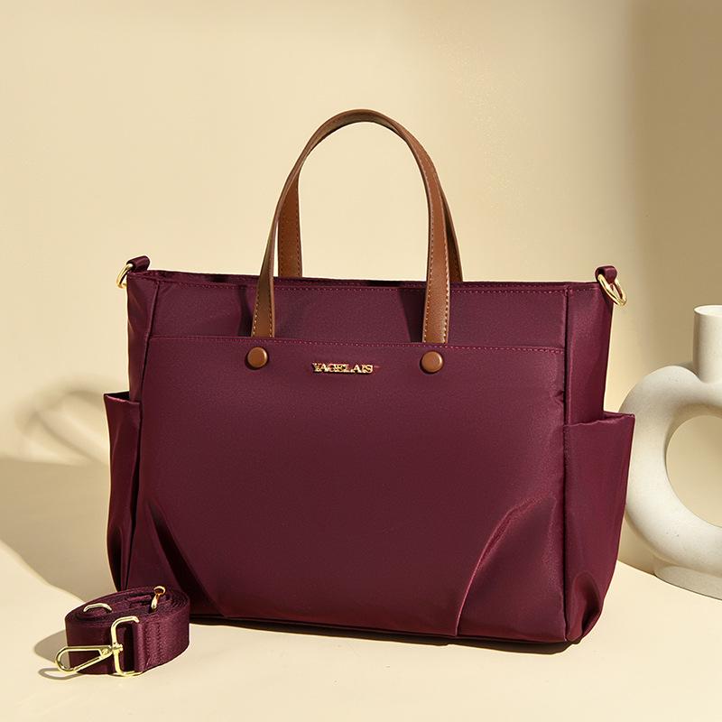 A Laptop Bag, A Lady Carrying A Business Briefcase and Slung A Commuter Tote Bag Across Her Shoulder