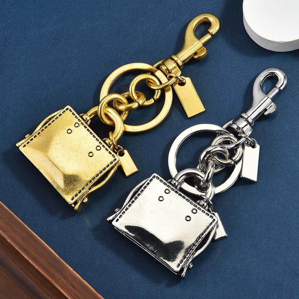 Metallic Keychain Bag Charm With Engraved Book Pattern For Fashion Accessories