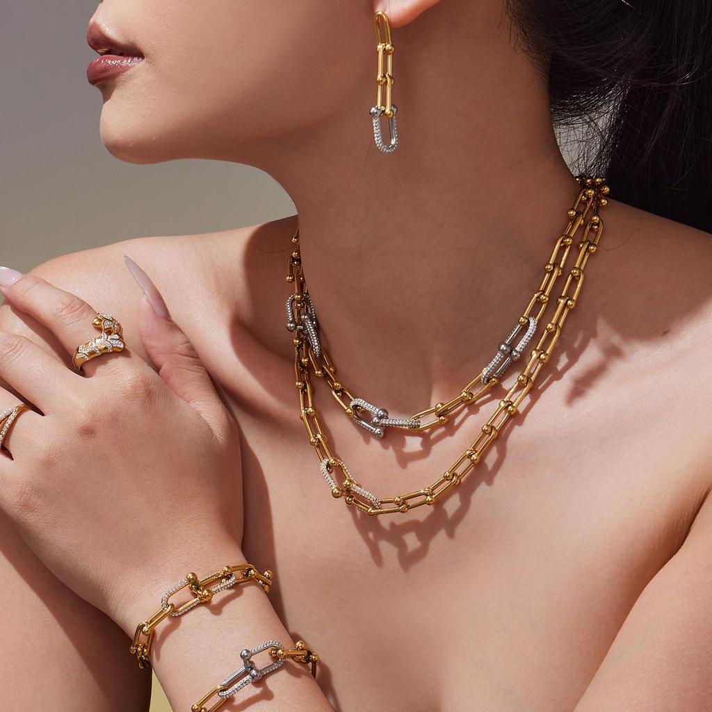 Qiong Yao U-förmiges vergoldetes Edelstahl-Schmuckset: Zirkonia Ohrringe, Halskette & Armband.